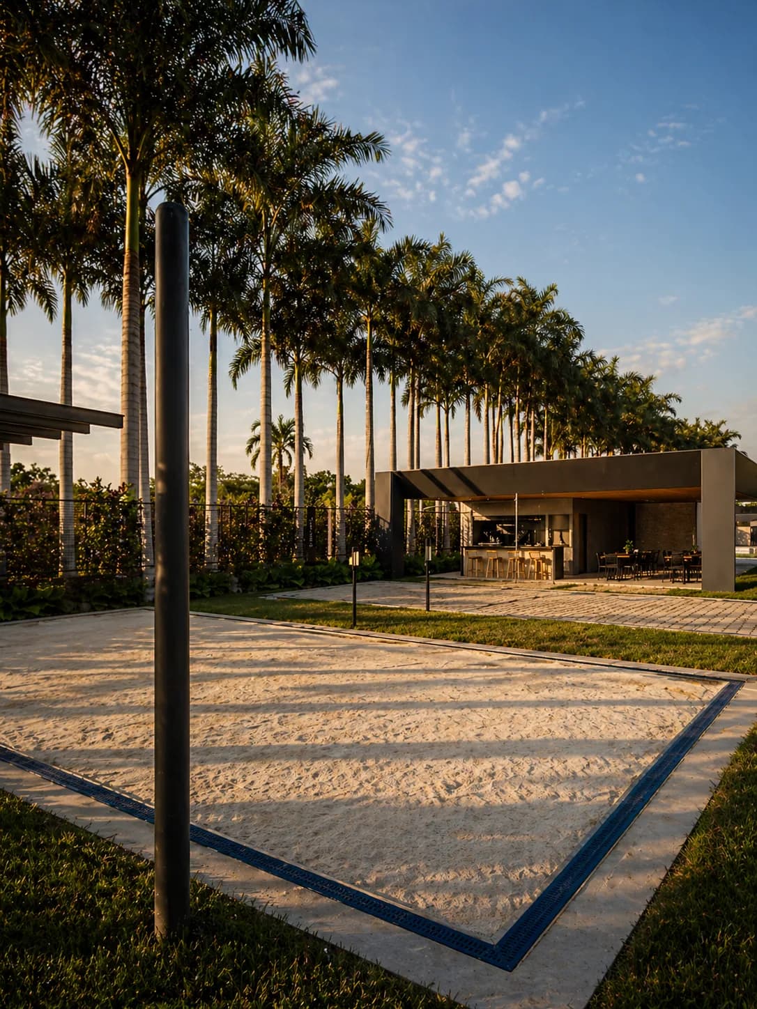 Quadra de beach tennis com palmeiras imperiais ao entardecer